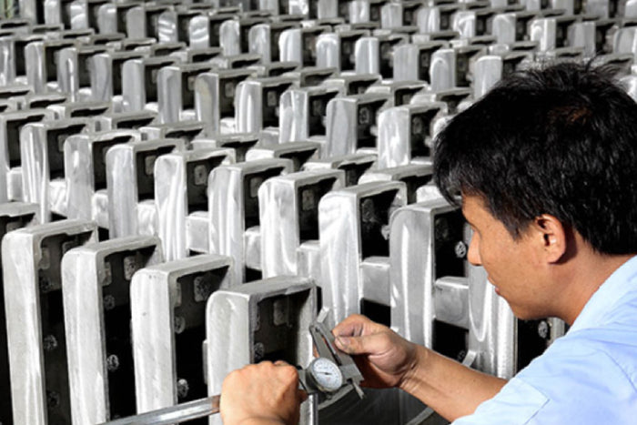 Person using a tool on electronic devices in a factory setting
